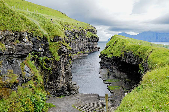 Gorge in Faroe Island with man walkiforemailng